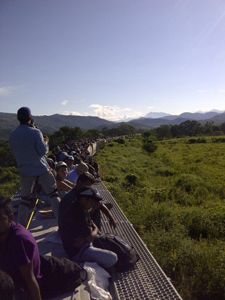 People sitting on top of a train.
