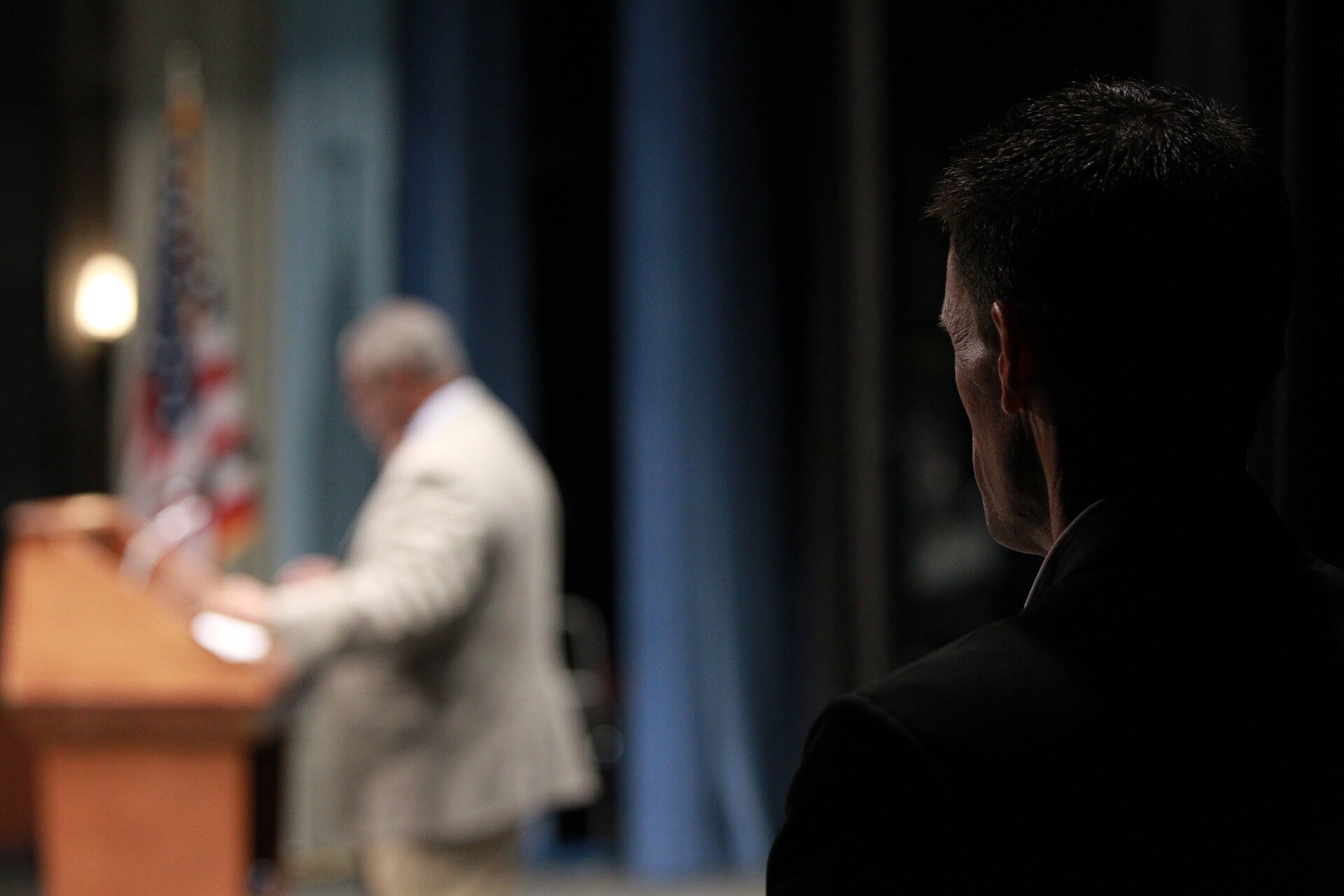 Body Guard protecting an executive while he speaks.