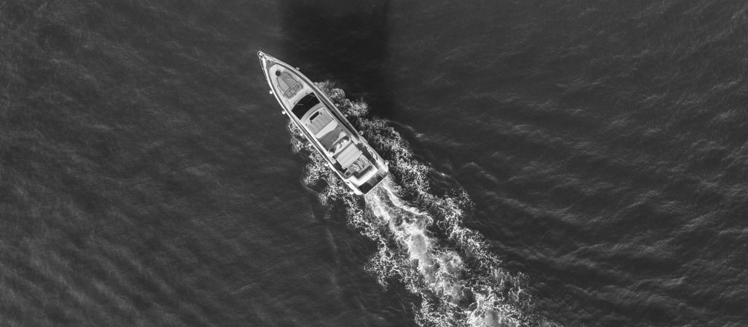 Yacht at the sea in Europe. Aerial view of luxury floating ship at sunset. Colorful landscape with boat in marina bay, blue sea. Top view from drone of yacht. Luxury cruise. Seascape with motorboat Aerial view of luxury floating ship at sunset.