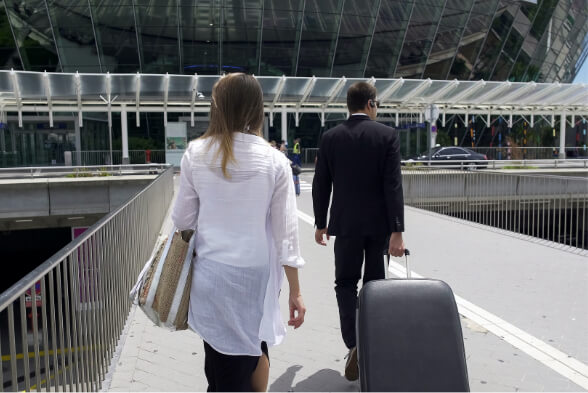 Body guard with luggage and female executive on their way to airport.