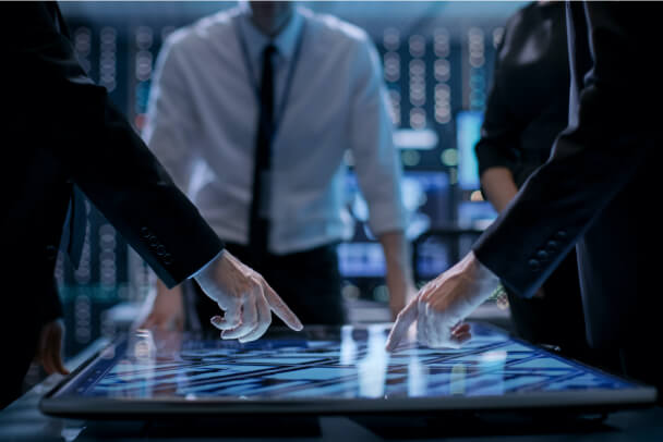 customized-site-security Executive pointing at a table with a map on it.