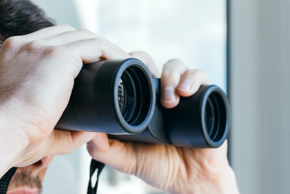 Security guard with a pair of binoculars on alert.