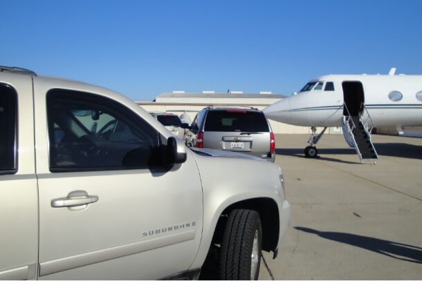 A Private airplane and convoy of security travel vehicles.
