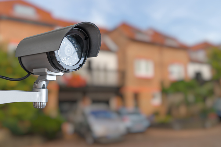 Security CCTV camera is monitoring home. Surveillance and safety concept. Security camera watching over a neighborhood