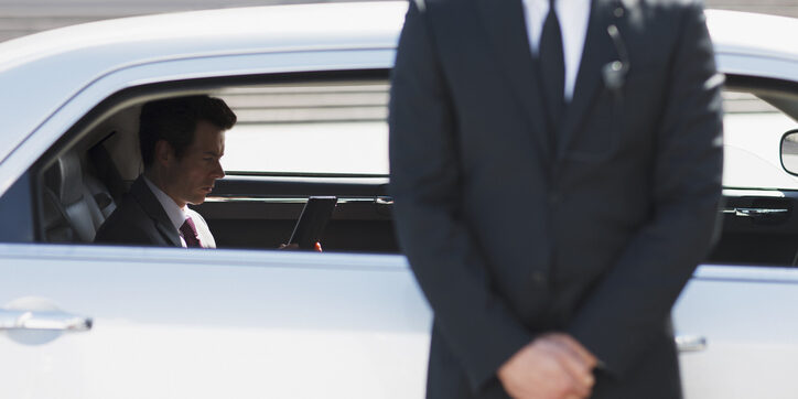 Bodyguard protecting politician in backseat of car